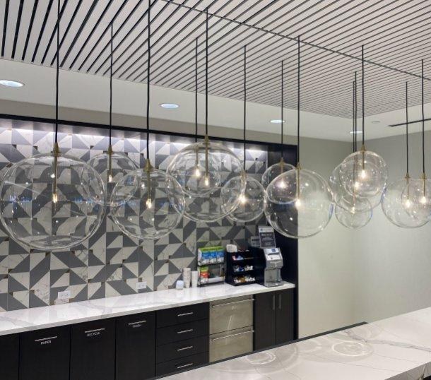 Glass globe pendants over an office coffee bar