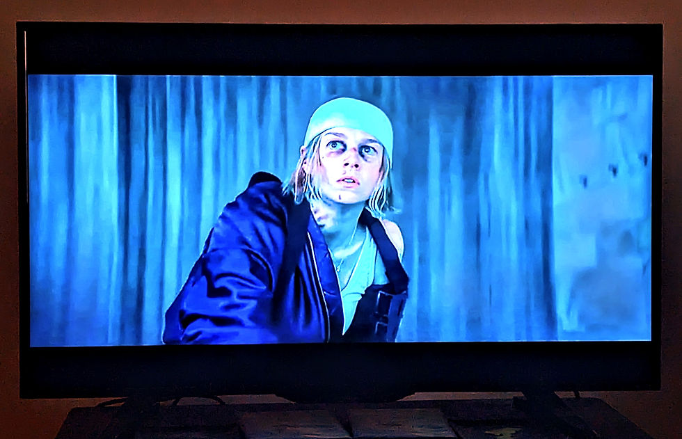 a bruised and bloody woman with a headband looks upward