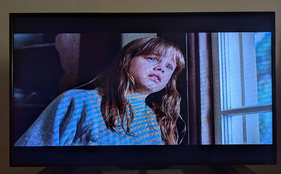 Dana Hill looking out the window as she leans her head on the windowframe