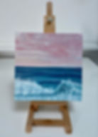 Oil painting of a wave breaking with a pink sunset.