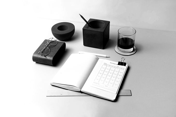Desk with open notebook, pen, glasses, and drink