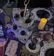 Themed table setting with tiered stand, potion bottles, and candle