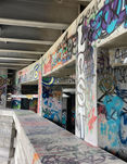 The walls are covered in colorful graffiti. The nearest column says "lost."