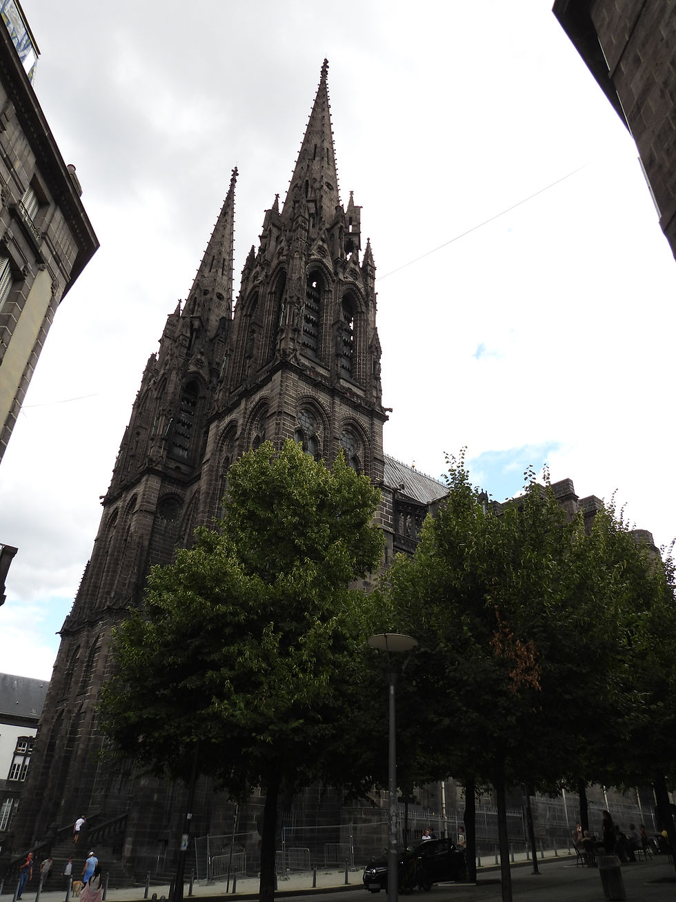 South and west facades behind mature trees of the Cathédrale Notre-Dame-de-l’Assomption, Clermont-Ferrand