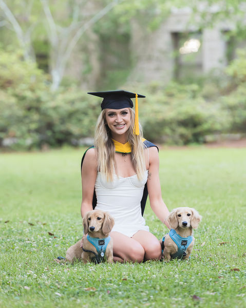 Woman sitting with her two pet dogs for graduation photos in New Orleans, Louisiana.