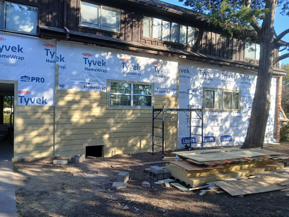 House under construction with Tyvek wrap and scaffolding.