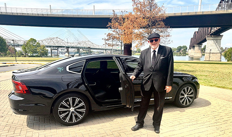Eye-level view of a sleek black luxury sedan parked on a city street