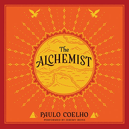 Audiobook cover for “The Alchemist” by Paulo Coelho, performed by Jeremy Irons. Warm red-orange design with ornate mandala-style circular sun motif in center, flanked by decorative birds and geometric patterns in yellow/gold.
