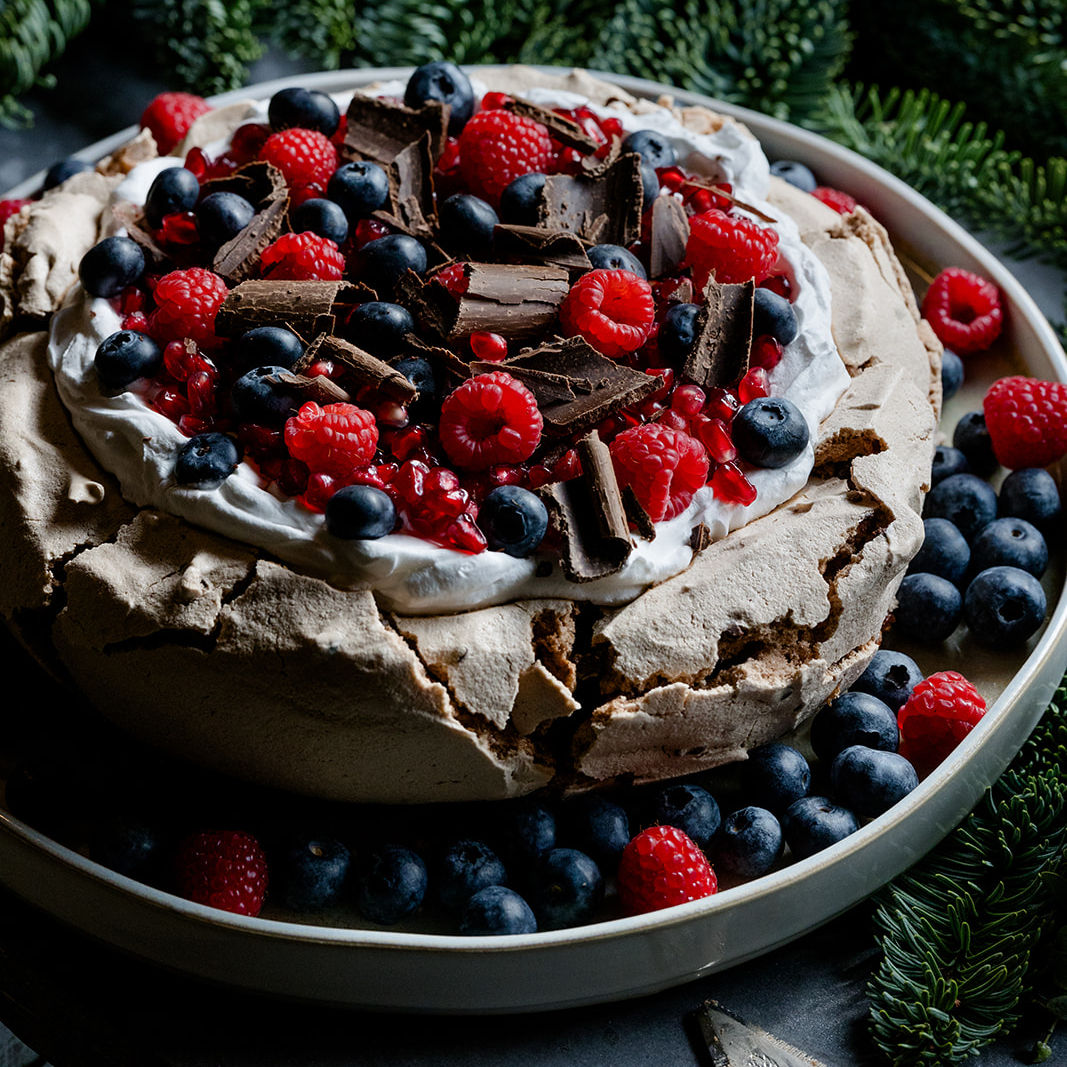 Suspiro de chocolate, natas, romã, frutos silvestres e raspas de chocolate