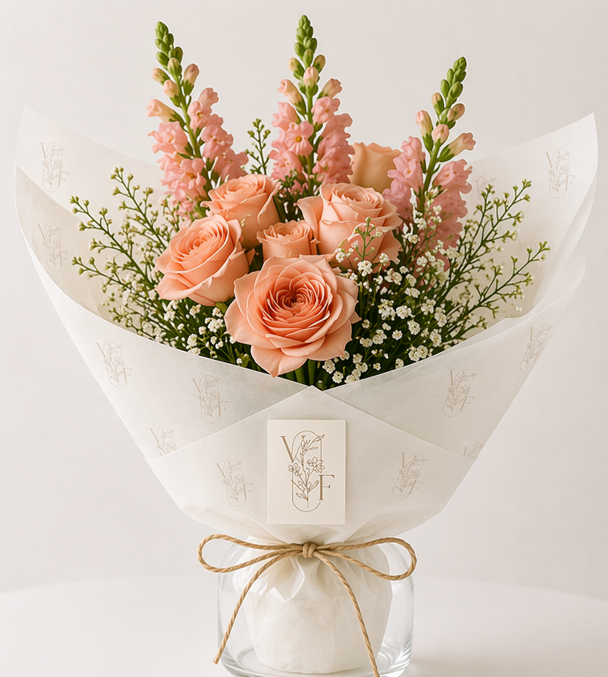 Peach rose bouquet with pink and white flowers wrapped in white paper