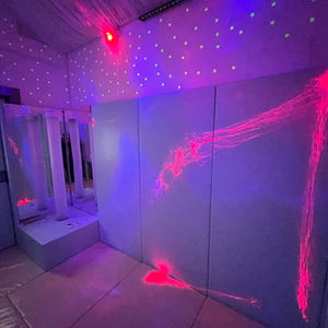 High level pale blue wall padding with chrome Tube mirrored corner with galaxy projectors, UV lights, LED lights, and Star Wall