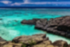 Black Rock, a tropical beach surrounded by black rocks, Rarotonga, Cook Islands.jpg