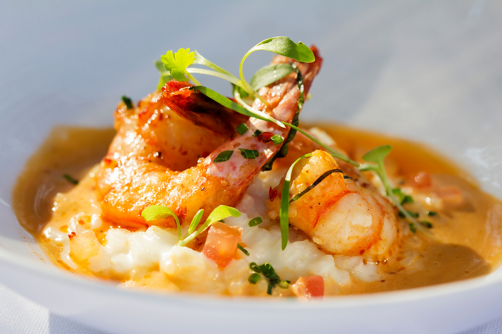 a close up photo of cooked prawn on top of a risotto