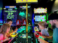 Family playing Pac-Man Battle Royale together at Push Start Play in Lewisville, Texas.