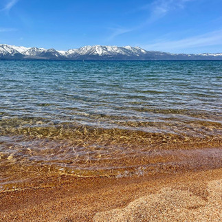 Crystal-clear water and snow-capped mountains at Nevada Beach in South Lake Tahoe, California.
