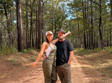 Jessica and Kevin wearing KÜHL KULTIVATR Overalls and Renegade Pants together on a wooded trail.