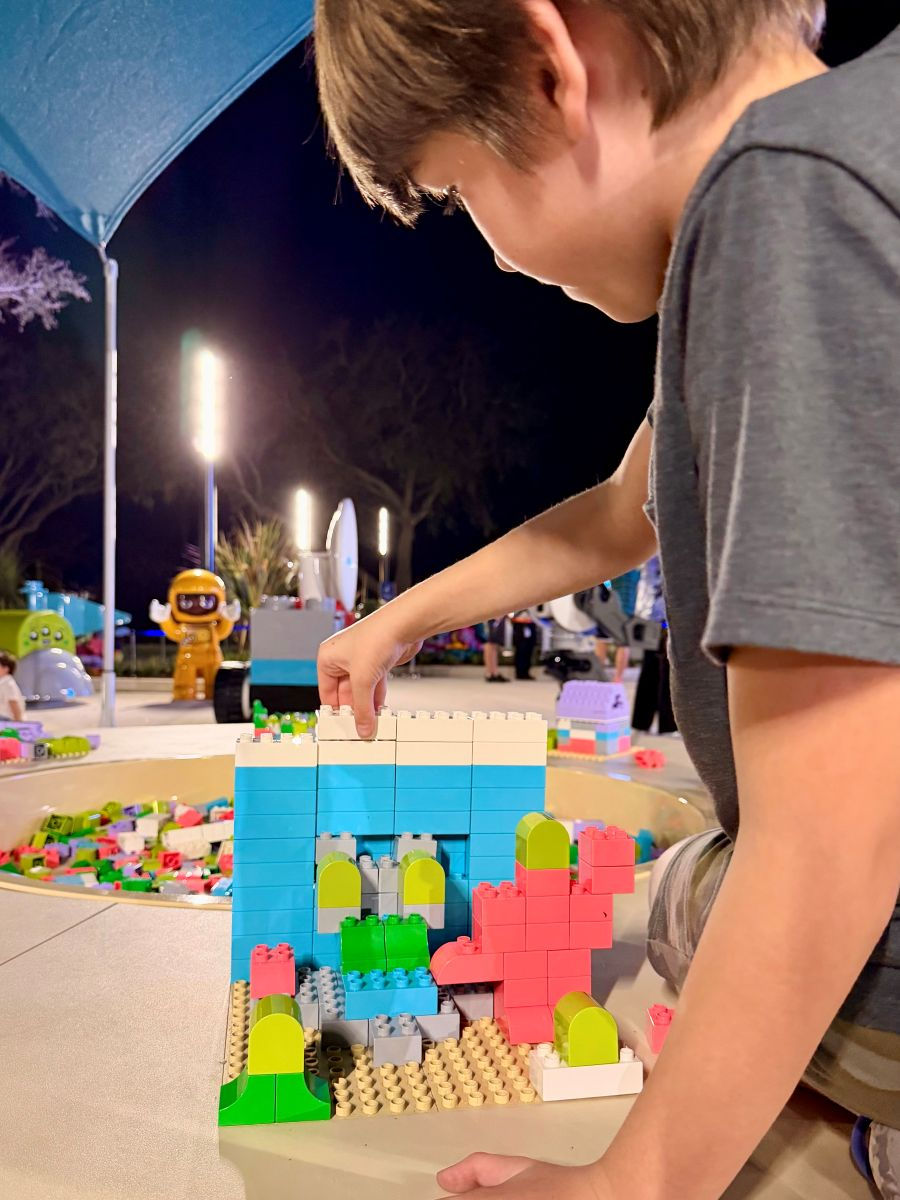 Kids building LEGO creations inside the LEGO Galaxy area at LEGOLAND Florida Resort.