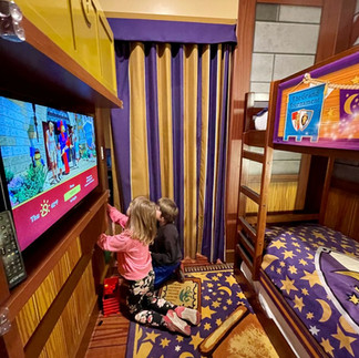 Kids enjoying the separate sleeping area inside a Magic Wizard Deluxe Room at LEGOLAND Castle Hotel.