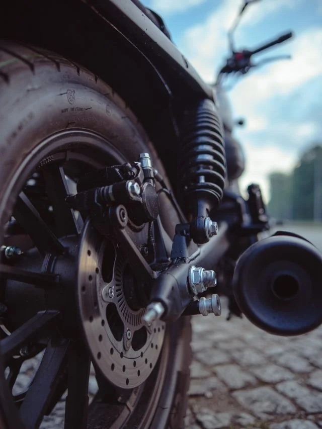 QJMOTOR SRV 12: Nahaufnahme der hinteren Bremsscheibe vor dem breiten Hinterreifen.