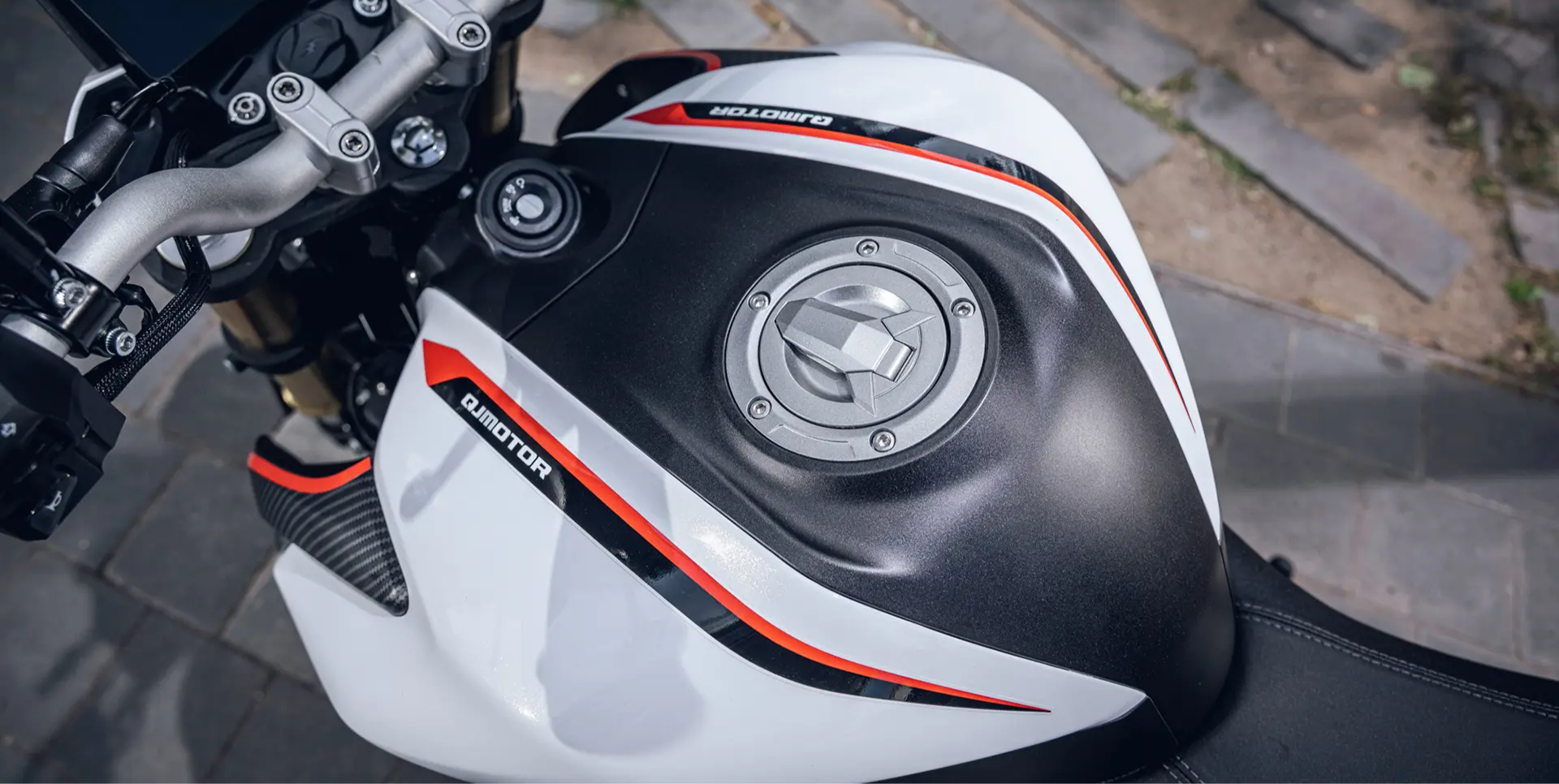 QJMOTOR SRK 125 S: Der Tank mit rundem Verschluss und weiß-roter seitlicher Verkleidung.