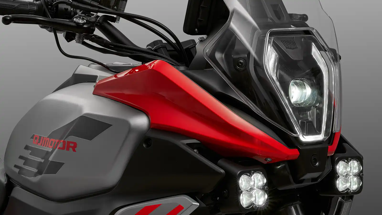 QJMOTOR SRT 600 SX: Die zweigeteilte Sitzbank mit rotem seitlichem Bezug und gepolsterten Sitzflächen.