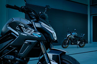 Blaue CFMOTO 125NK im Vordergrund; eine zweite Maschine mit Fahrer steht dahinter in der Unterführung.