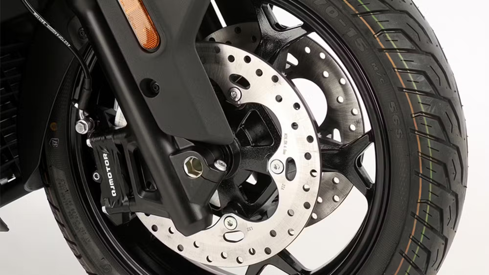 QJMOTOR FORT 4.0: Nahaufnahme einer vorderen gelochten Bremsscheibe mit Gabel und Bremssattel.
