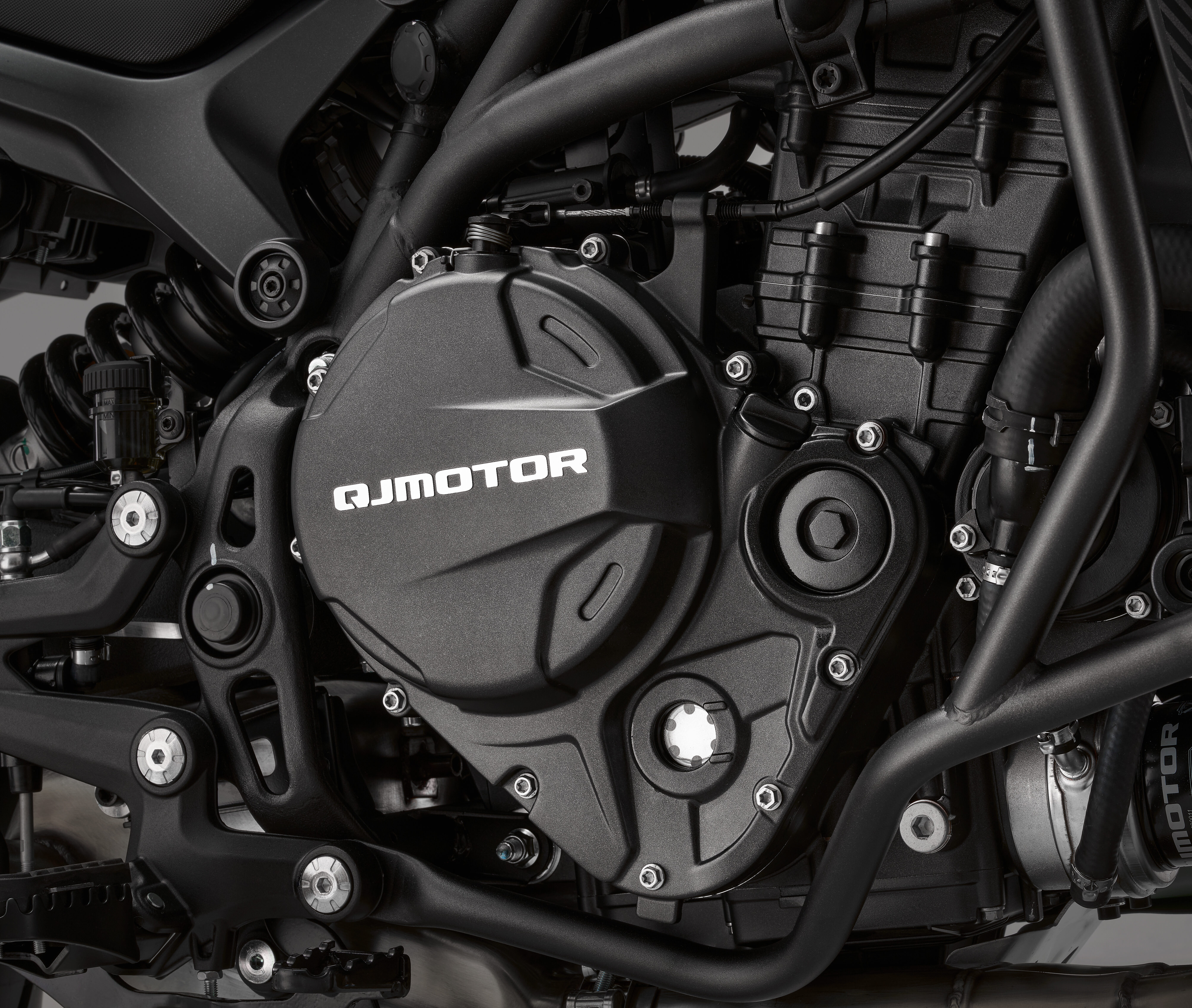 QJMOTOR SRT 900 SX: Nahaufnahme des Zweizylindermotors mit dunklem Gehäuse und Rahmenbauteilen.