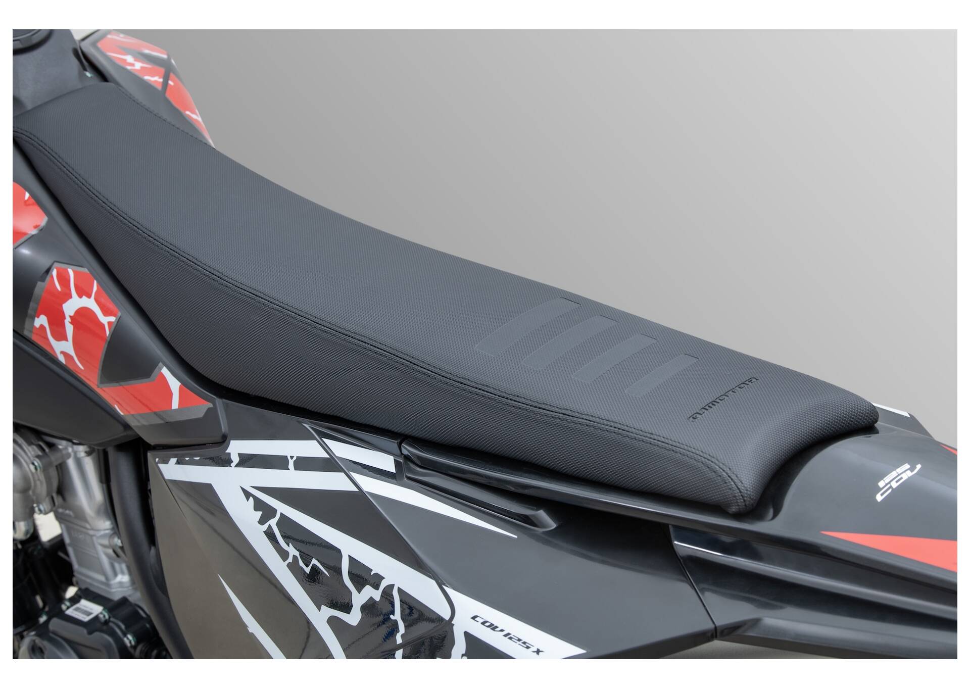 QJMOTOR COV 125 X: Die schmale schwarze Sitzbank über der weiß-roten Heckverkleidung.