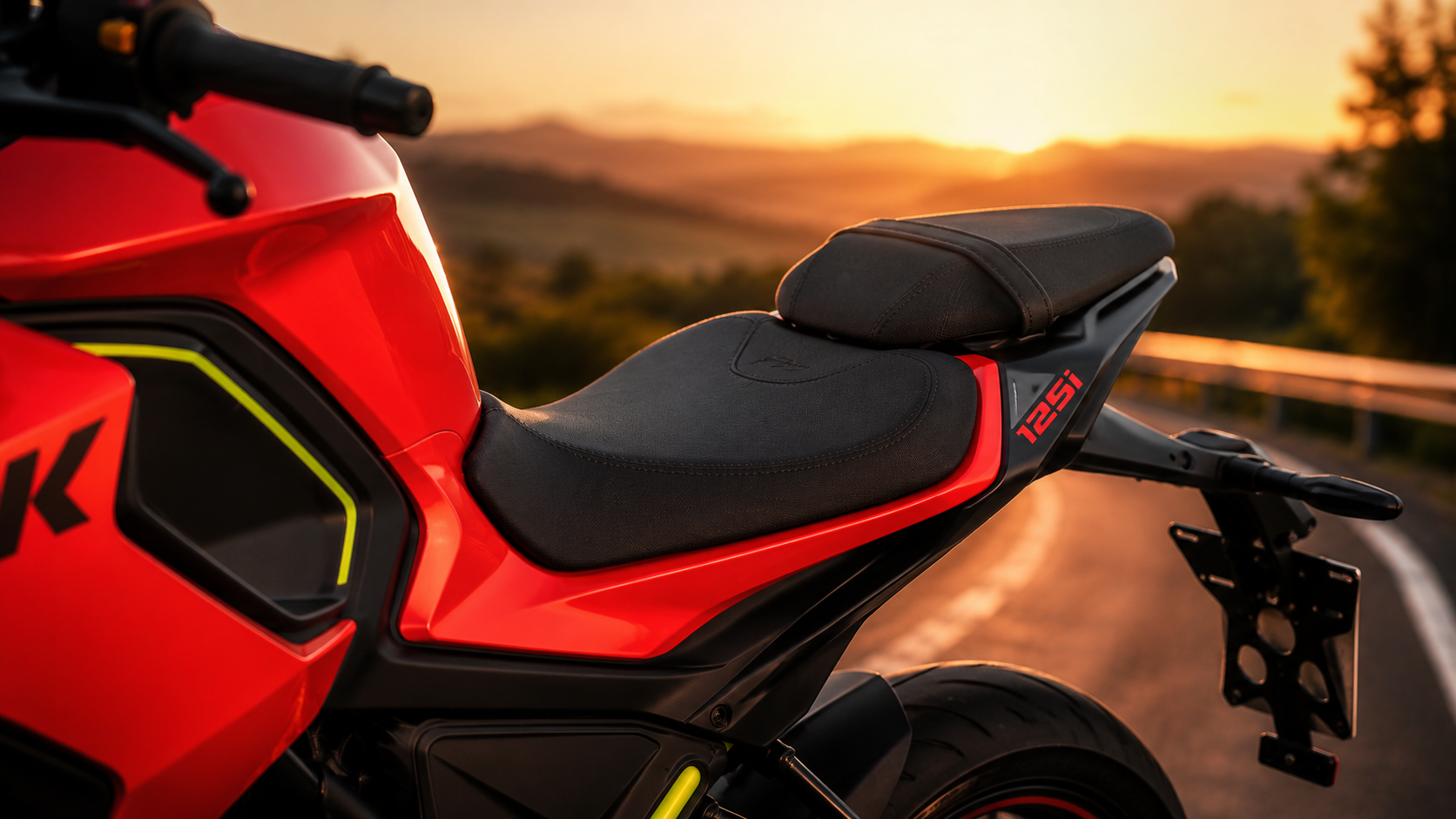 QJMOTOR SRK 125 RW: Die zweigeteilte Sitzbank und das rot lackierte Heck vor einer Landschaft im Abendlicht.