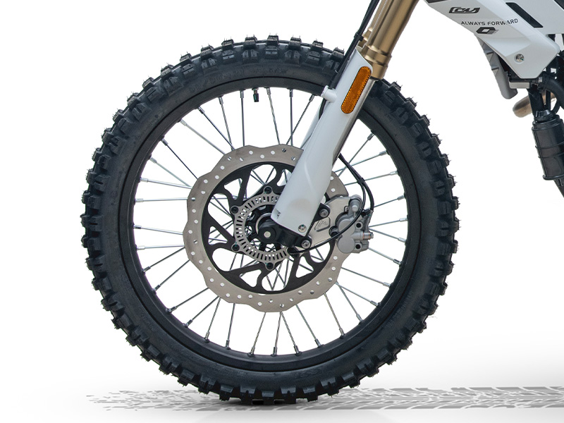 QJMOTOR COV 125 X: Das Vorderrad mit grobem Reifenprofil und großer gelochter Bremsscheibe.