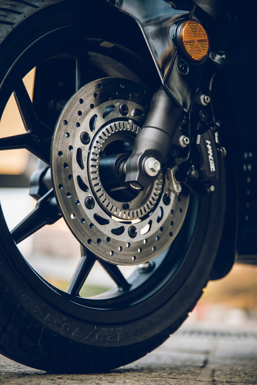 QJMOTOR FORT 125 N: Die Front mit hellem Scheinwerfer und orange leuchtenden Blinkern.