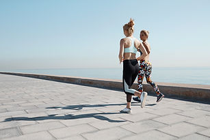 Two Girls Jogging by Water