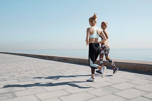 Zwei Mädchen Joggen durch Wasser