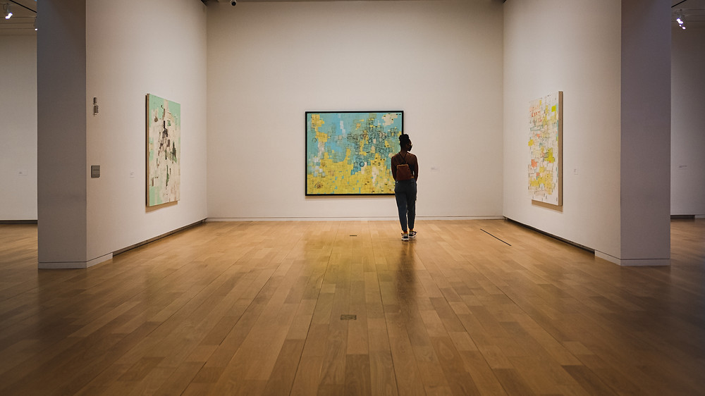 A young woman looks at collage art.