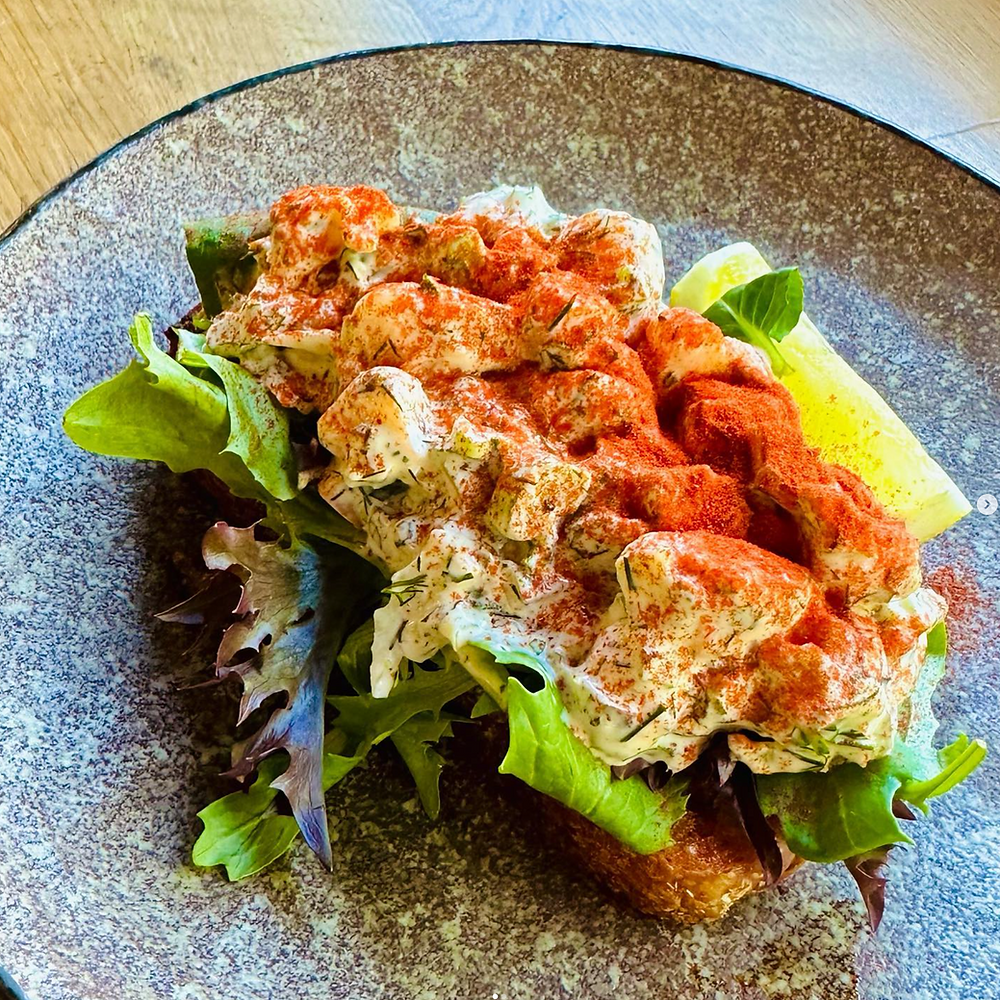 Creamy salad on toasted bread with lettuce and lemon