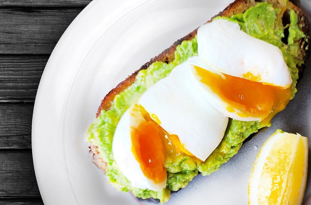Avocado toast with poached eggs on organic bread
