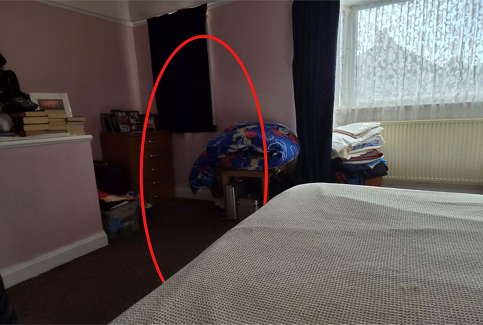 Photograph of the bedroom indicating the position where the taller figure was standing