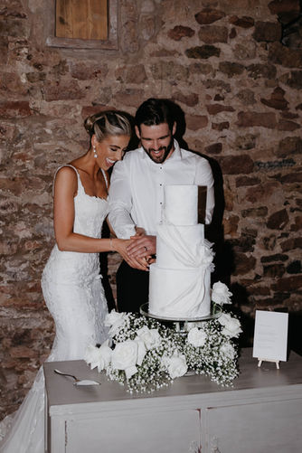 Bride and groom cut three tier wedding cake