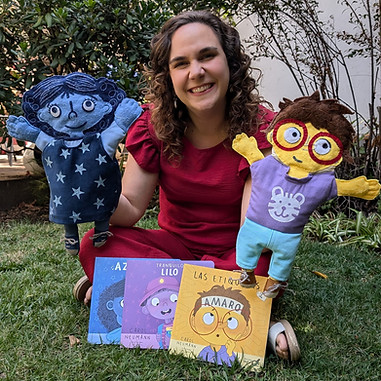 Carol Neumann, autora de libros infantiles, mostrando tres de sus libros