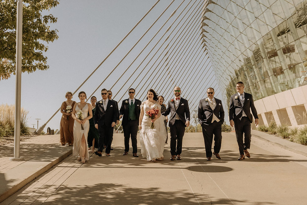 A wedding party walks with Kauffman Center in the background
