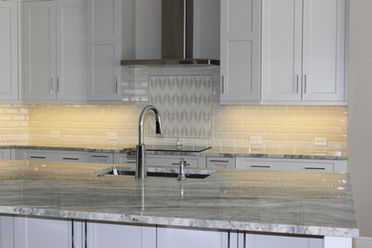 Updated kitchen with custom cabinetry, backsplash, and stainless steel appliances