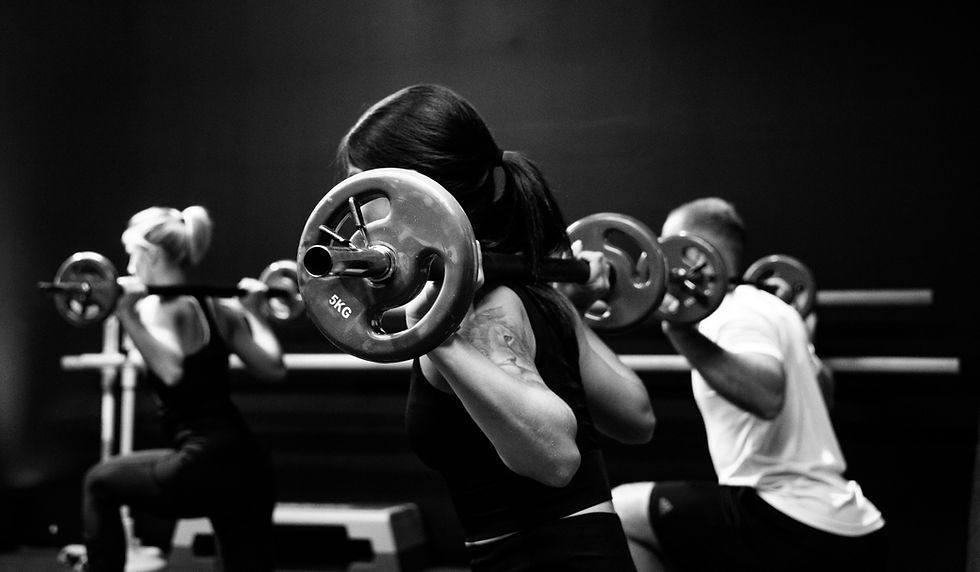 People doing weightlifting in a social fitness workout in the gym