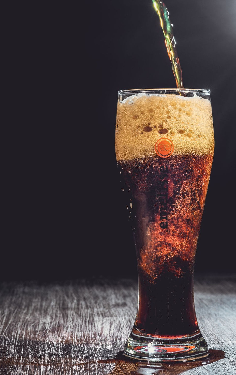 dark beer pouring into the glass with 