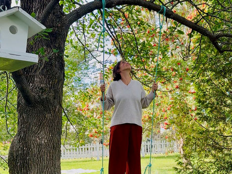 Femme en équilibre sur une balançoire de jardin symbolisant la fluidité, les émotions et l’équilibre intérieur