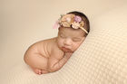 Professional newborn photos Melbourne – baby on beanbag in cream headband
