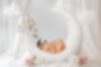 Newborn baby sleeping peacefullyon moon prop