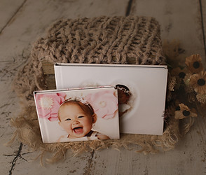 Personalized newborn photo album with custom cover design and high-resolution prints, providing a beautiful keepsake for home