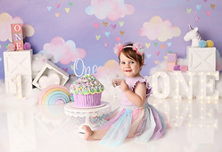 Cute Little girl eating and smashing her cake. Unicorn Rainbow Cake Smash Theme