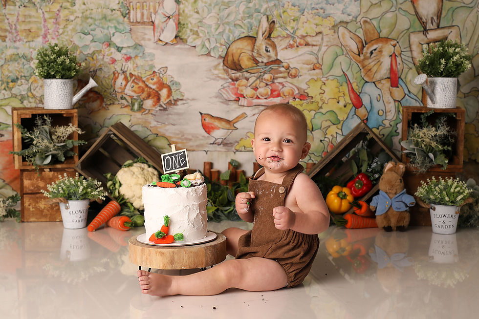 A boy celebrates with a vintage Peter Rabbit-themed cake smash, surrounded by classic bunny decor